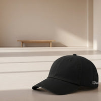 Load image into Gallery viewer, Personalised Discreet Embroidery Cap Black Colourway - Lifestyle Shot in a living room, minimalist Scandinavian style

