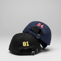 Load image into Gallery viewer, Two baseball caps with numbers on a grid background
