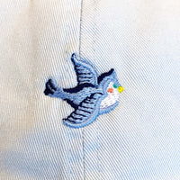 Load image into Gallery viewer, pale blue canvas cap with an embroidered vintage bluebird motif on the front.

